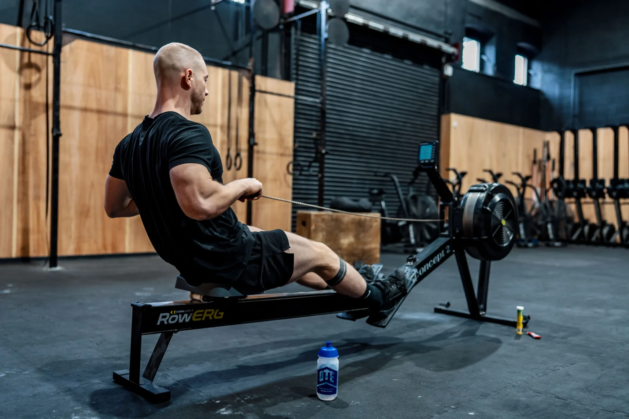 Athlete rowing in a dark gym environment