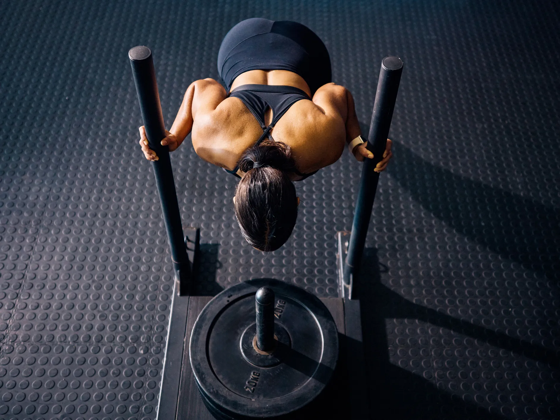Overhead view of athlete pushing a weighted sled